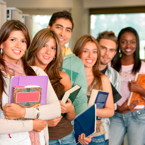 Grupo de estudiantes universitarios ordenados en fila y cada uno sosteniendo un elemento de estudio.