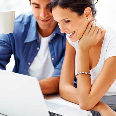 Dos personas en un ambiente laboral observan la pantalla de un computador portátil.