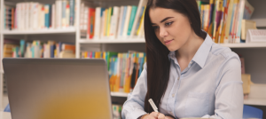 Mujer en estudio frente a un computador portátil.