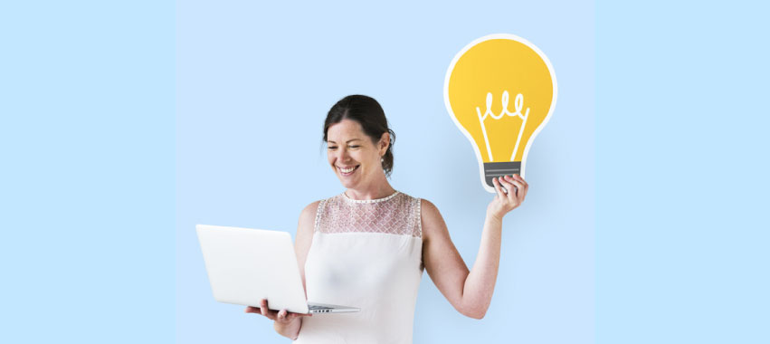 Mujer emprendedora sostiene la ilustración de una bombilla encendida, además de un computador portátil.