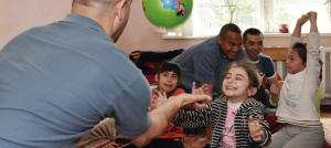 Grupo de personas mayores juegan con niños en situación de discapacidad.