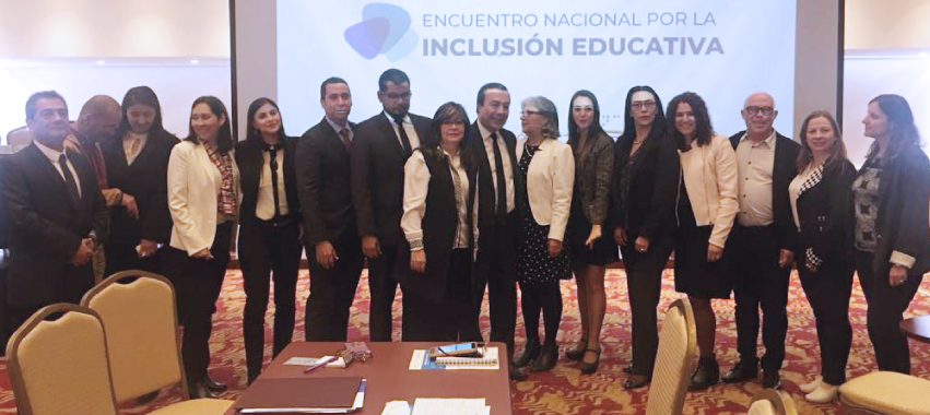 Dieciséis personas, una al lado de la otra, al frente de una mesa. Texto: Encuentro Nacional por la Inclusión Educativa.
