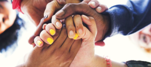 Manos de muchas personas se unen en señal de ayuda y amistad.