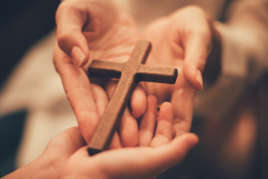 Dos manos sosteniendo un crucifijo