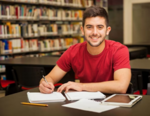Joven estudiando en una biblioteca.
