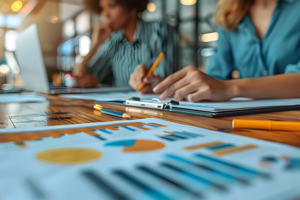 Grupo de gerentes de proyectos sentadas a la mesa en un ambiente laboral.